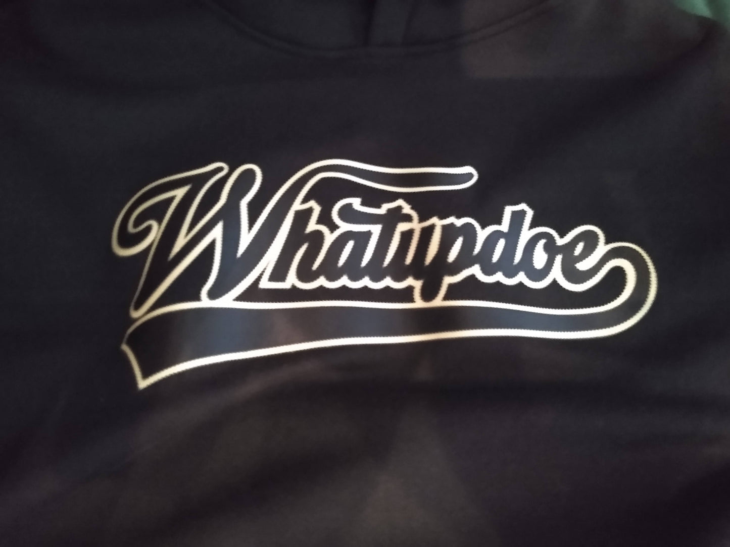 Black hoodie with 'Whatupdoe' logo in black and gold. Simulated two layer stitching to look like embroidery, using Stahl's Sim Stitch twill heat transfers.