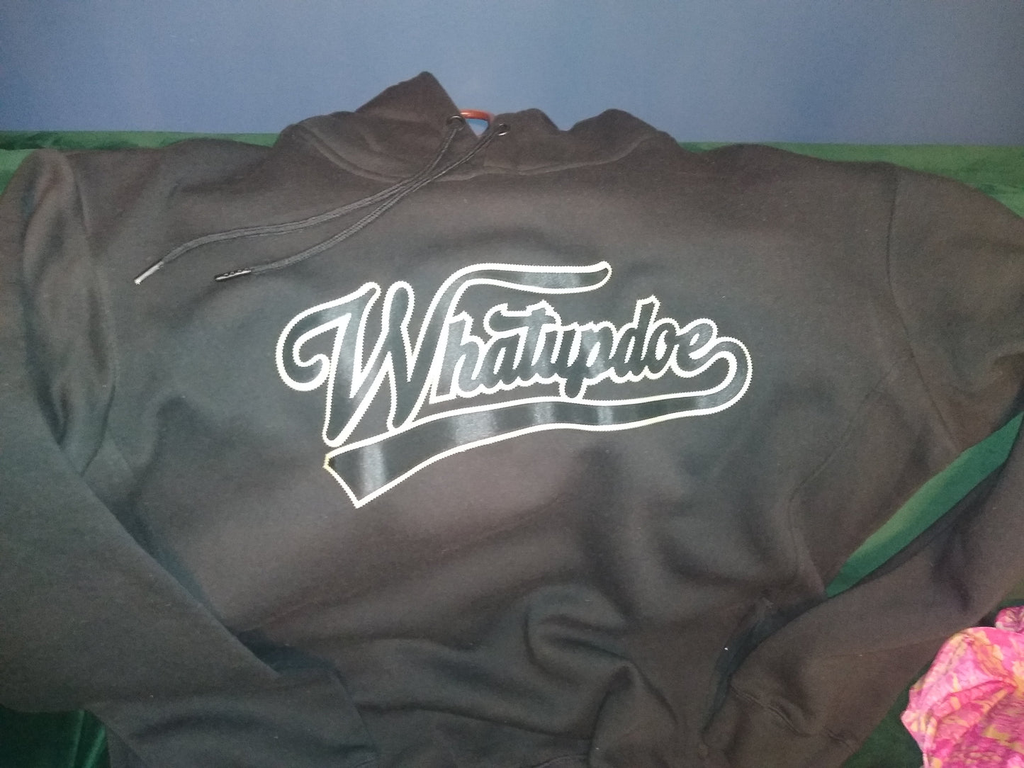 Black hoodie with 'Whatupdoe' logo on black and gold heat transfer. Simulated two layer stitching to look like embroidery, using Stahl's Sim Stitch twill heat transfers.